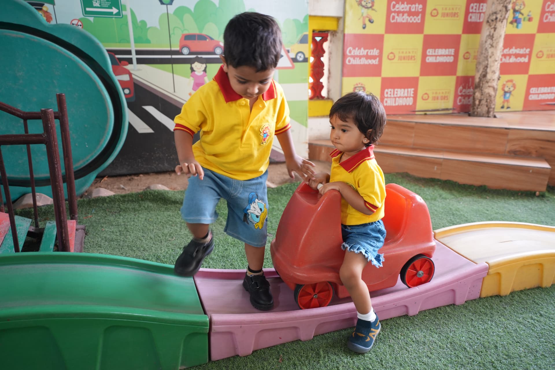 Children playing on ride-on toys in the play area
